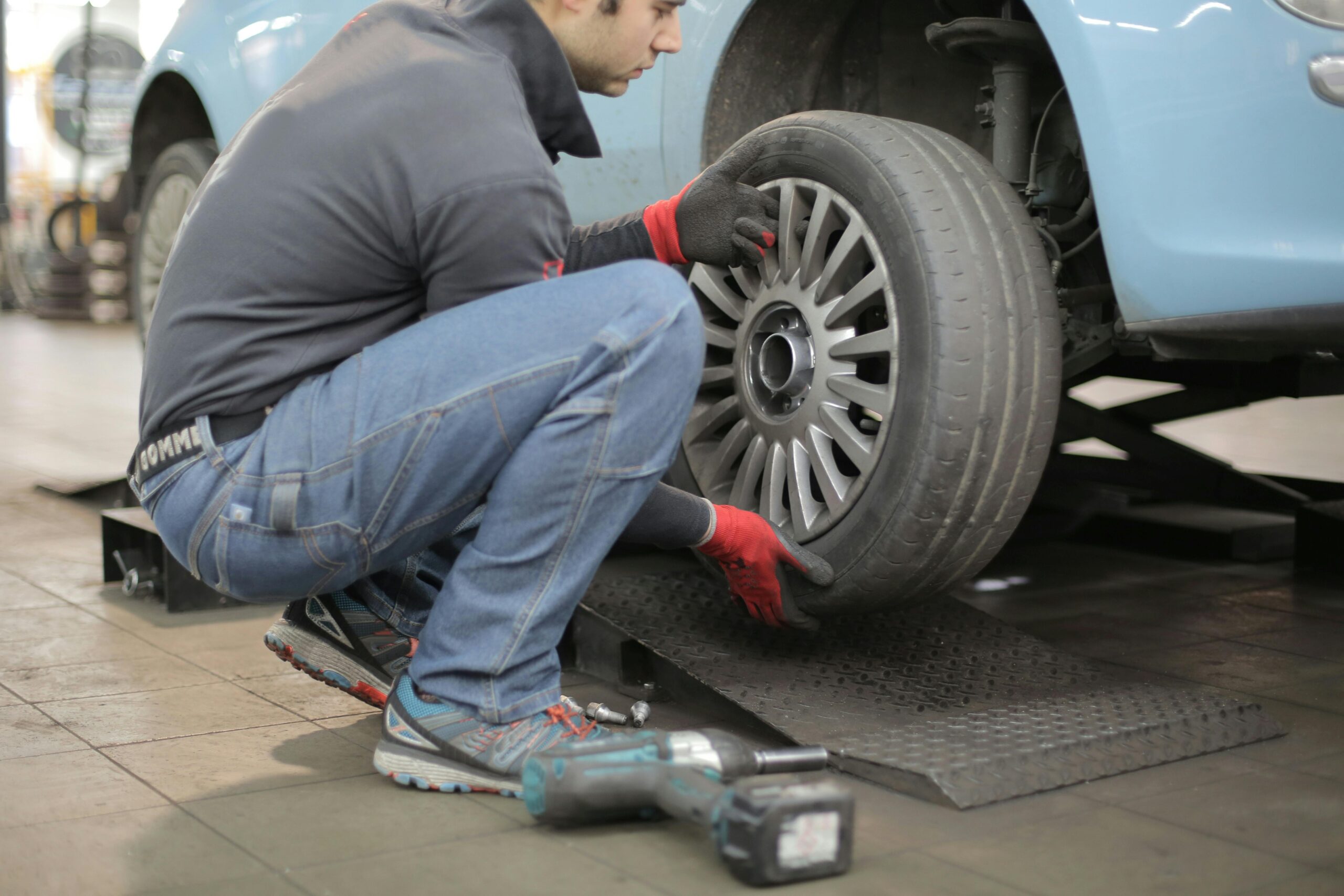 A man fitting a tyre to a car.